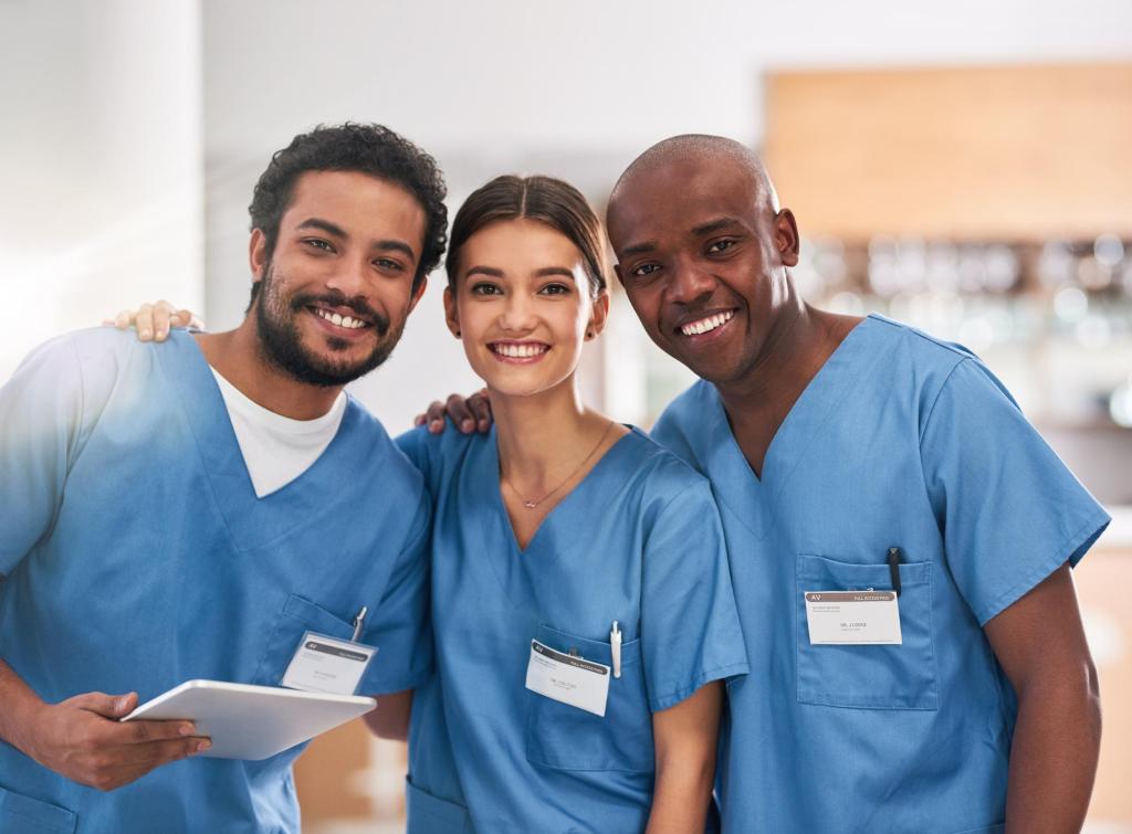 Cheerful young doctors stand together with digital tablet inside hospital.