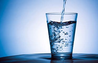 water being poured into a glass cup more than half full