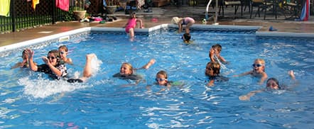 multiple children swimming in a pool