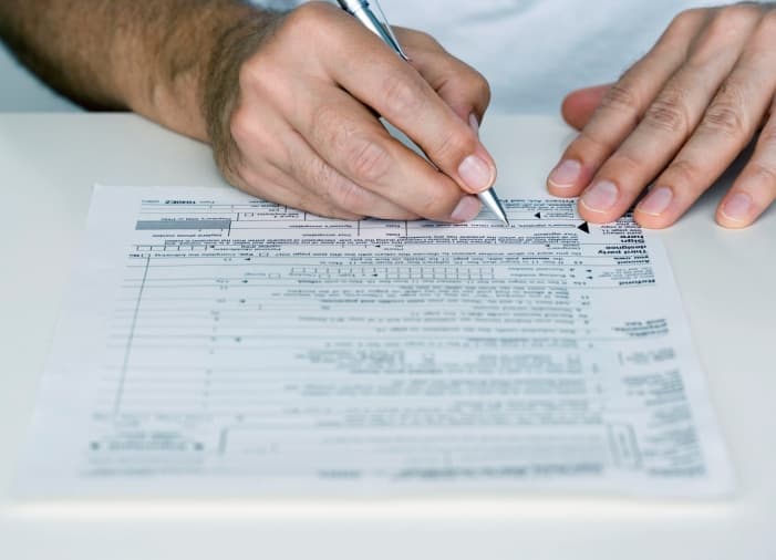 close up view of man filling out a form focused in on the form