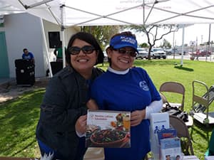 two public health employees embracing one another at a Public Health event